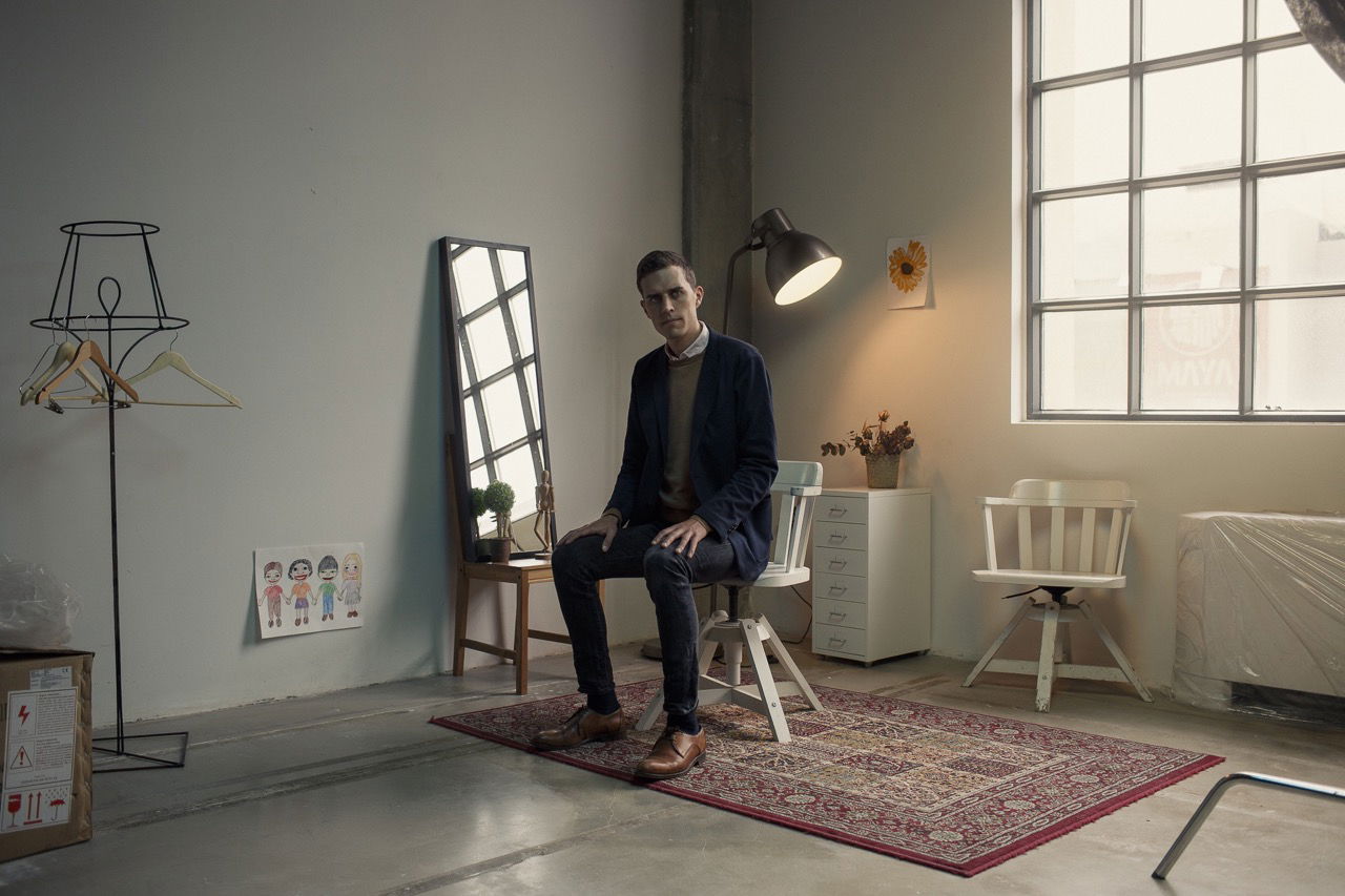 Midjourney prompt engineering techniques illustrated in minimalist studio setting with Danish performance artist Christian Falsnaes.