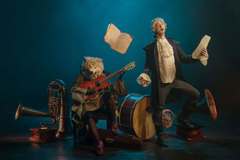 Wolf guitarist and singing conductor with brass instruments in warm theatrical stage lighting