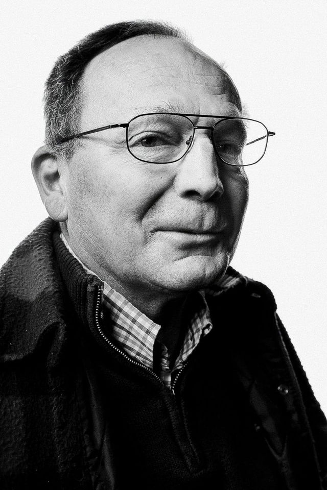 Portrait of a bespectacled man in high-contrast black-and-white photography with bright light