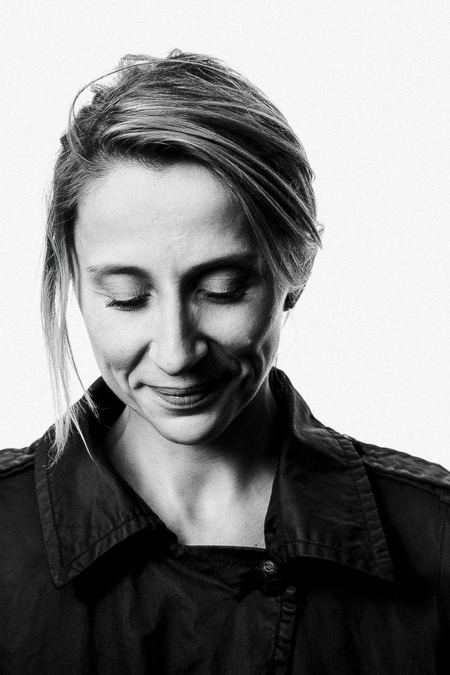 Woman with eyes closed and a slight smile, high-contrast black-and-white portrait photography