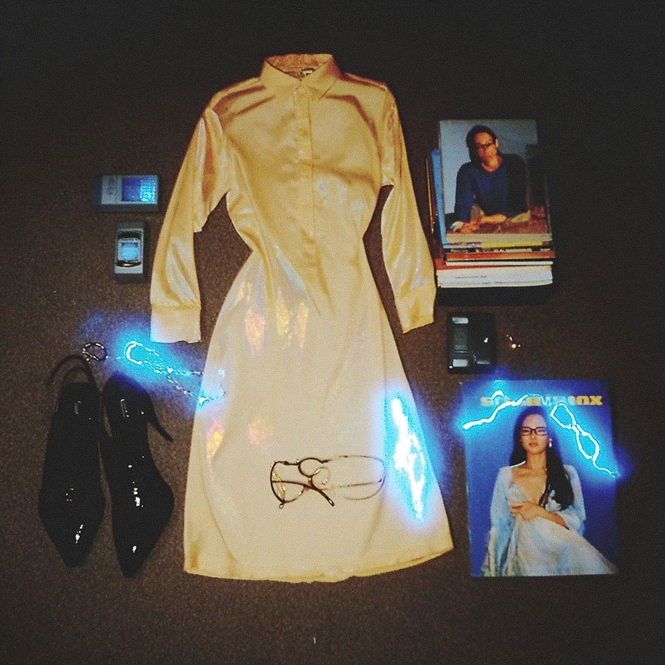 Iridescent high-fashion librarian outfit with books and glasses, photographed in dark neon light