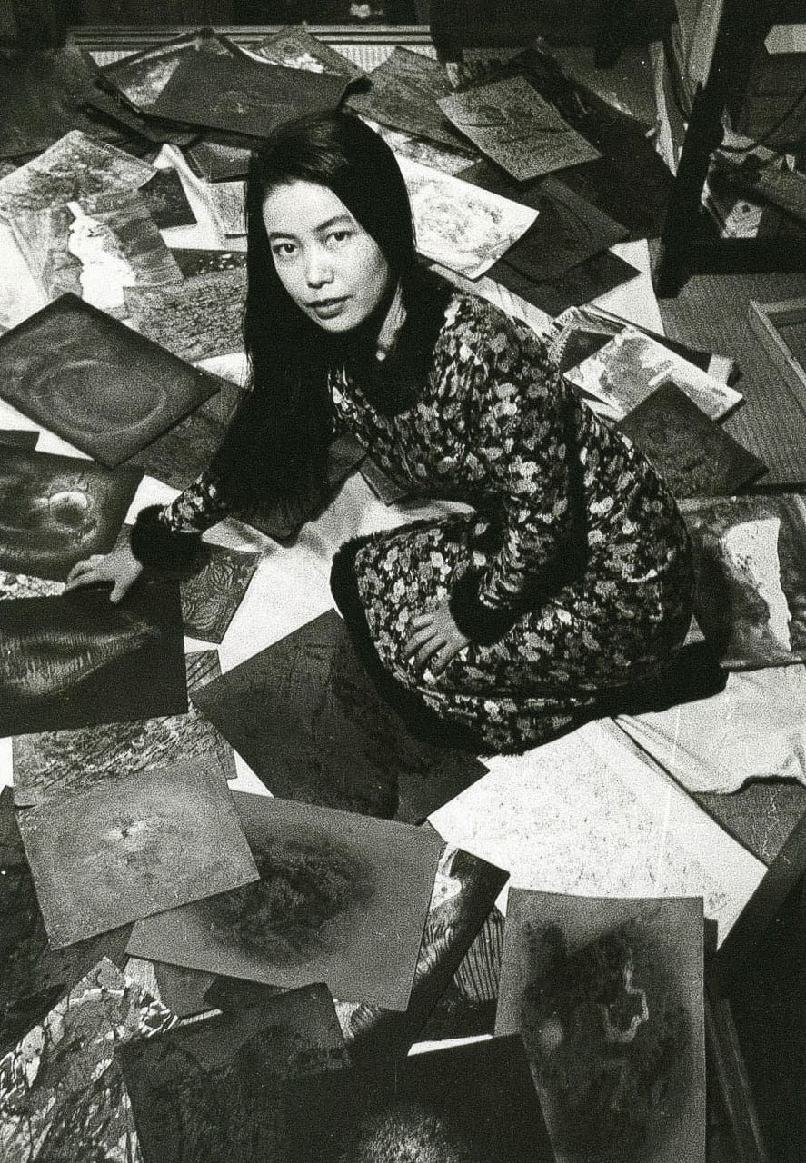 Yayoi Kusama in studio surrounded by artwork, exploring Midjourney prompts for polka dots and vibrant colors.
